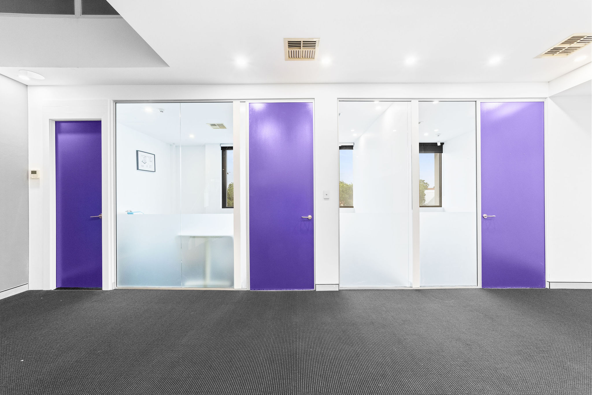 Main office with double-height void and purple feature doors